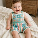 Baby boy wearing the ocean breeze granny square crochet romper on a bed