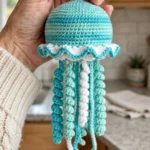 Ocean blue crochet jellyfish keychain held in a hand