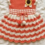 Coral and cream shell fan baby dress laid flat