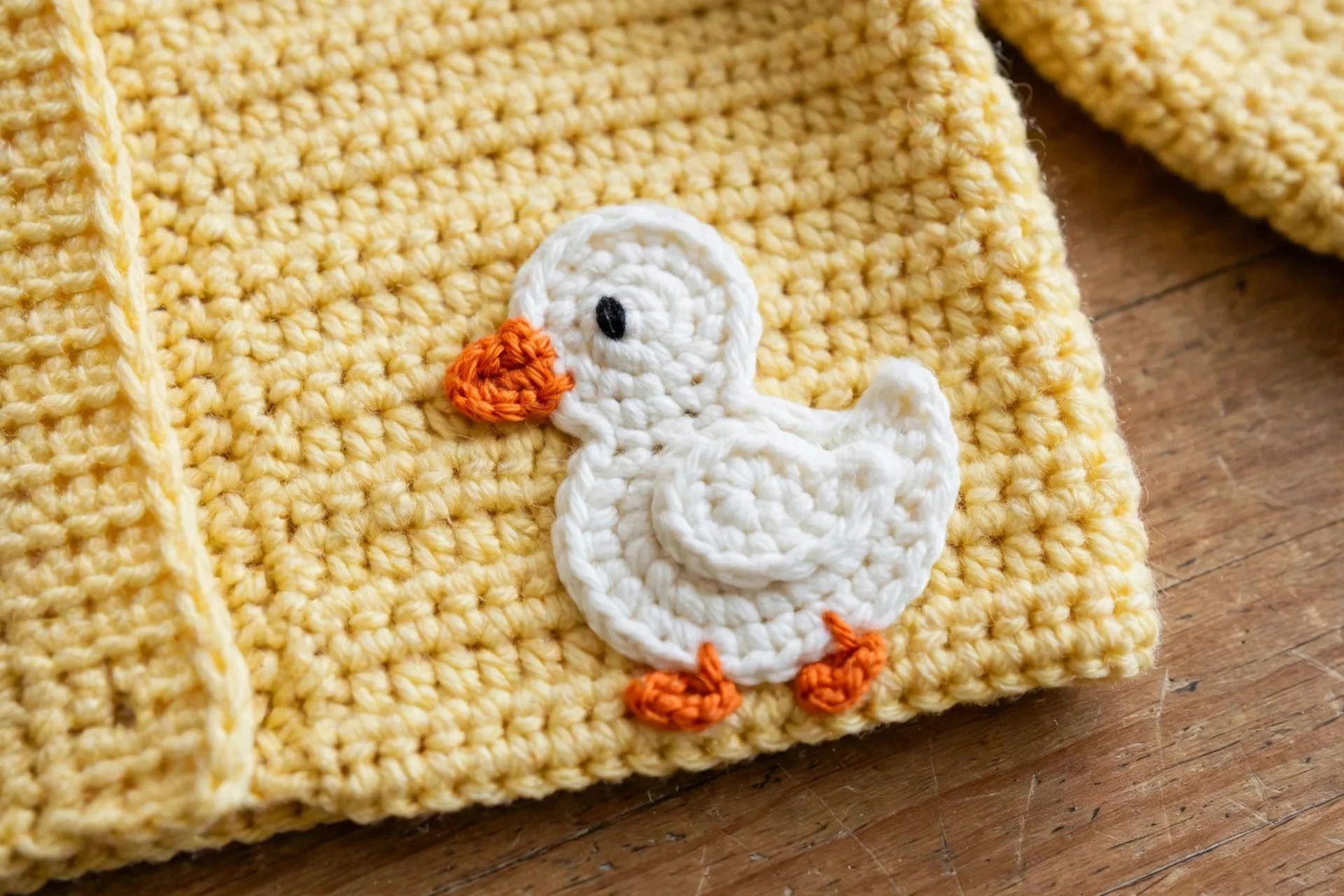 Close-up of the yellow duck applique sewn on the sweater front