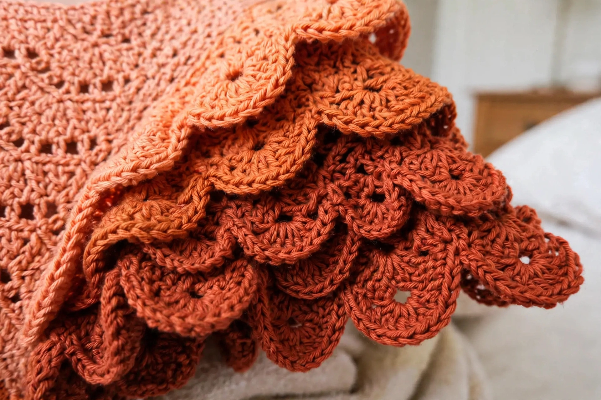 Close-up of the shell lace stitch texture on the sunset orange crochet dress